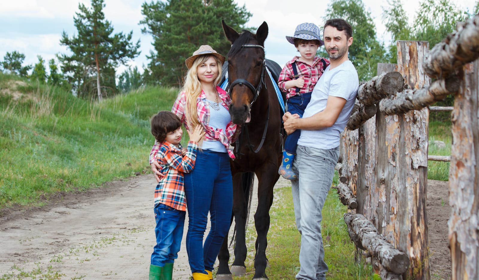 Family standing together beside a horse outdoors